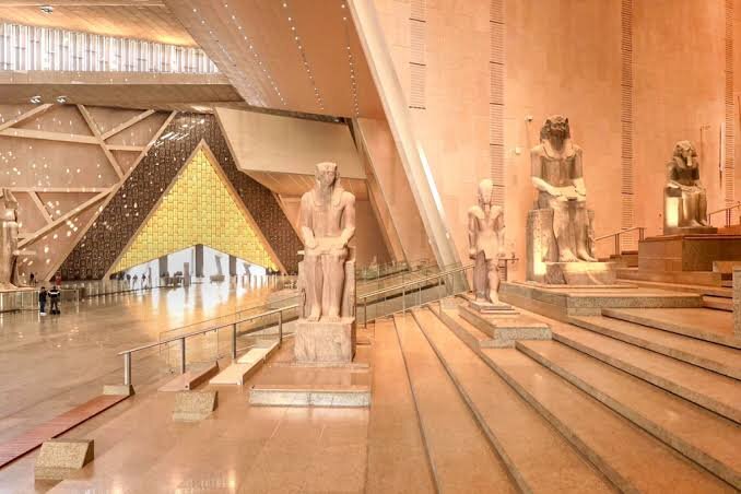 Pharaonic statues lining the grand staircase of the Grand Egyptian Museum