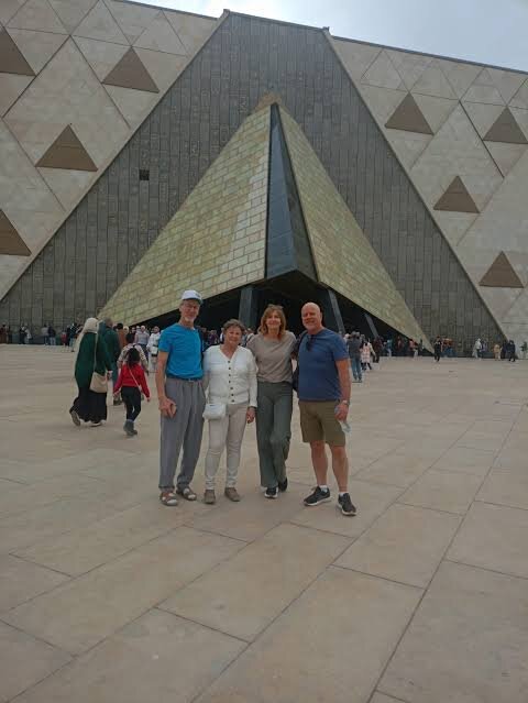 Small group in front of the pyramid-shaped entrance of the Grand Egyptian Museum