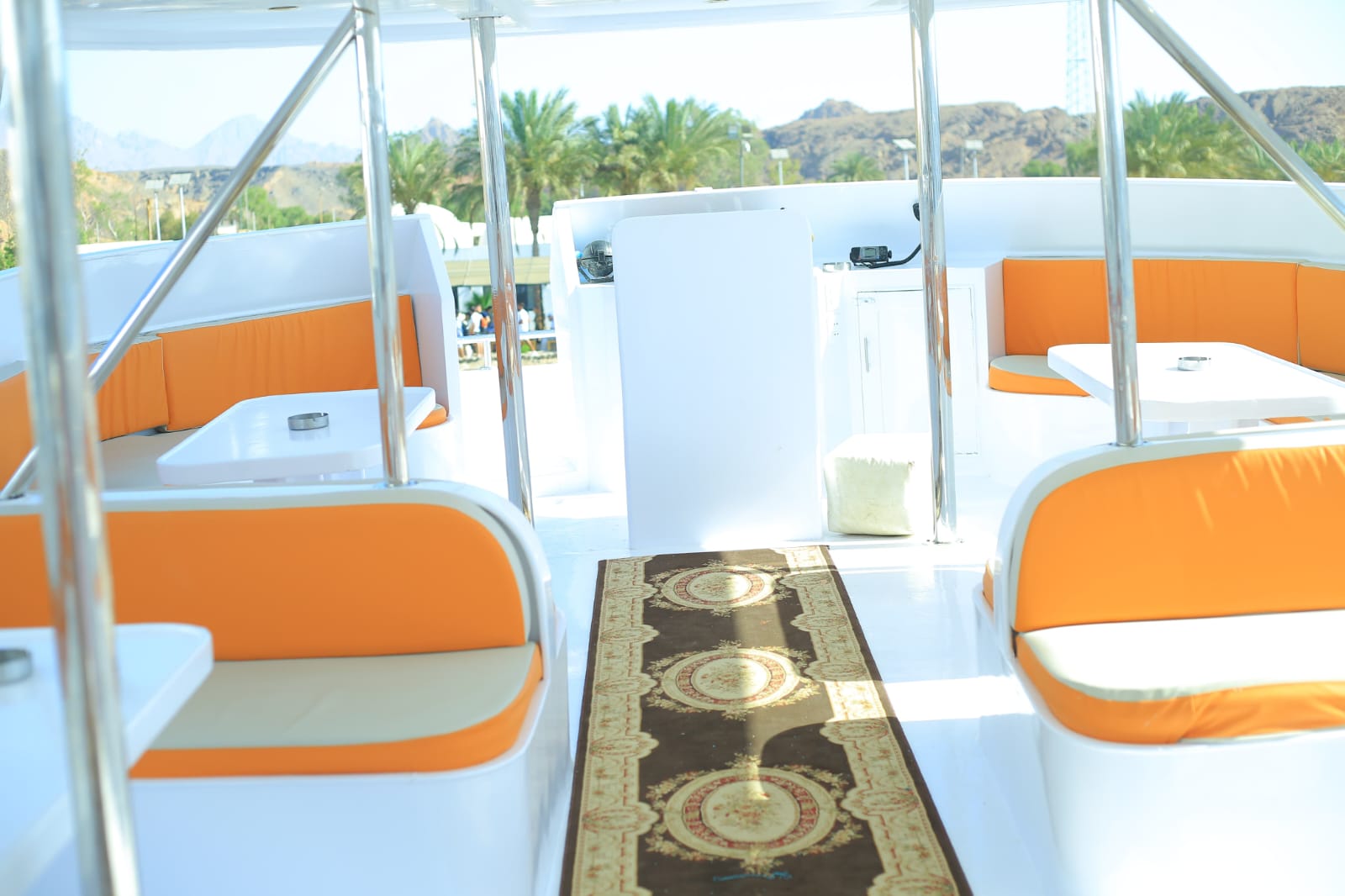 Spacious boat lounge area with traditional rug and orange seating