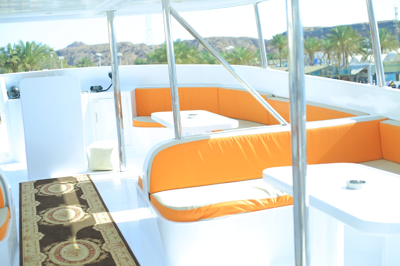 Boat interior side view with orange cushions and mountain backdrop
