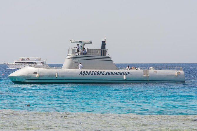 White semi-submarine moored in shallow turquoise water off the coast